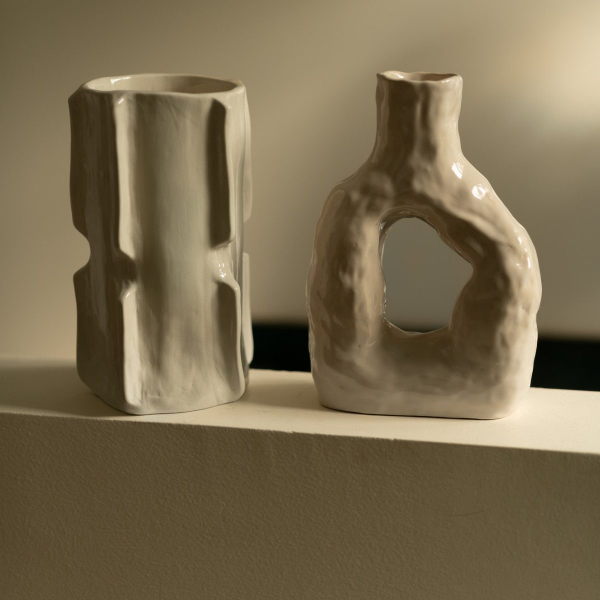 Deux vases émaillés en transparent, d’une couleur entre le blanc cassé et le beige