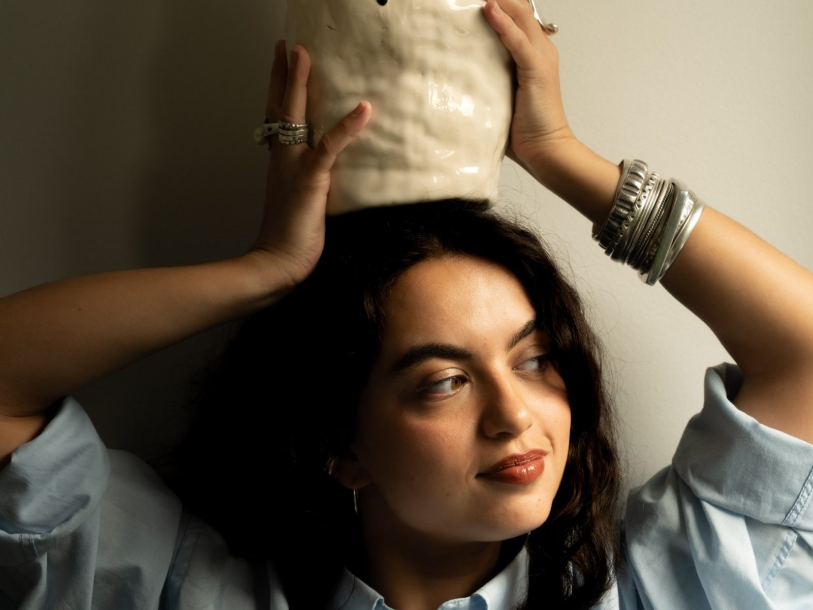 Marie D’Antoni tenant un vase en céramique sur la tête